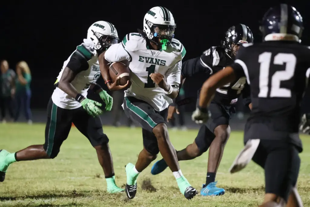 Evans High quarterback William Jackson (1) scrambles during the Evans...