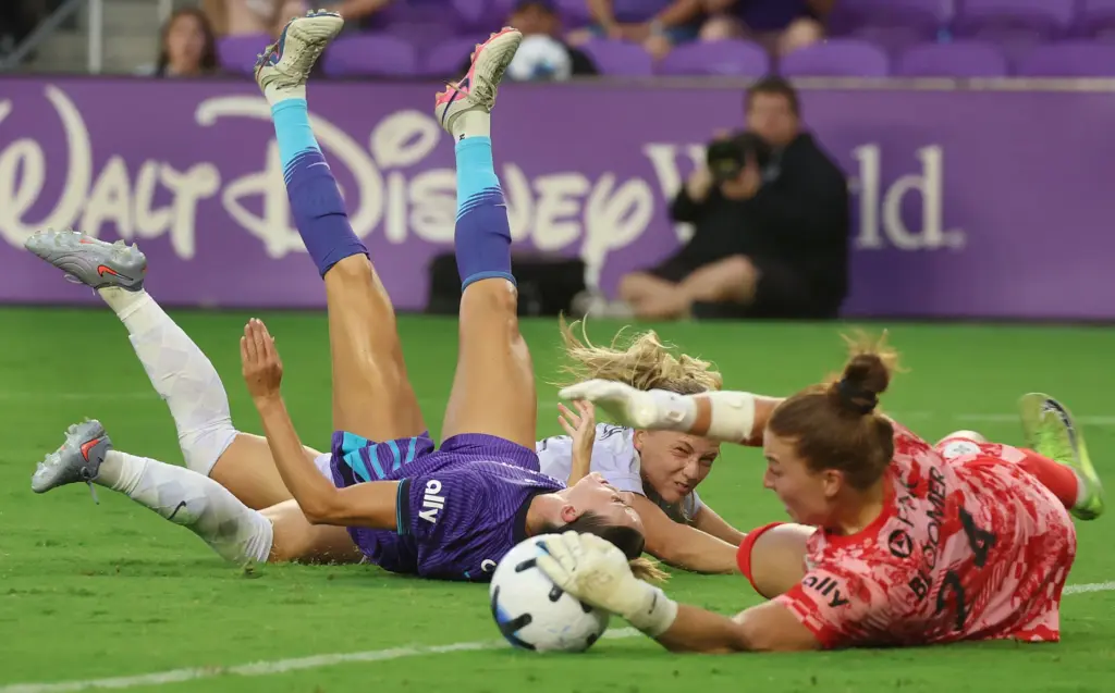 Orlando player Julie Doyle (left) falls after colliding with Louisville...