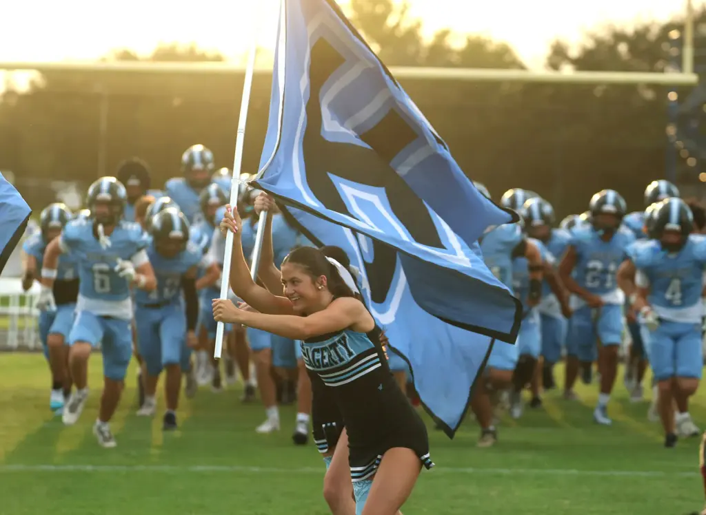 Cheerleaders lead the Hagerty team onto the field for the...