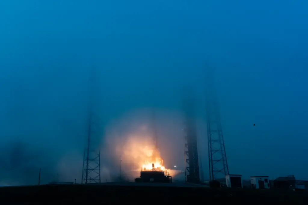A SpaceX Falcon 9 launches through the fog from Cape...