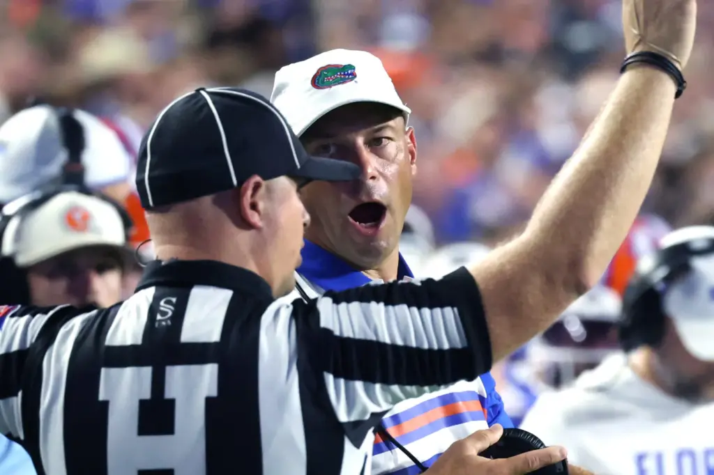 Florida head coach Jon Sumrall converses with game official Adam...
