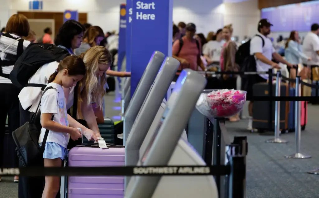 Travelers check-in at Southwest Airlines in the Orlando International Airport,...