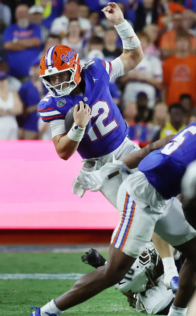 Florida quarterback Aaron Philo (12) leaps from defenders during the...