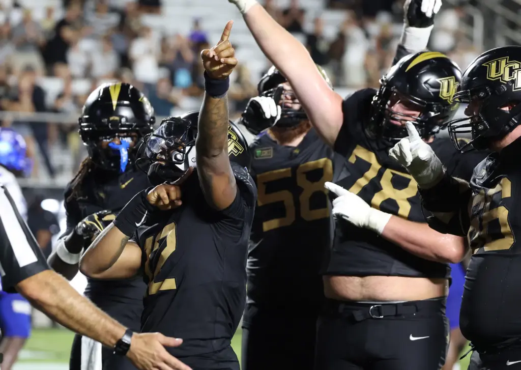 UCF quarterback Keyone Jenkins (12) celebrates with teammates after he...
