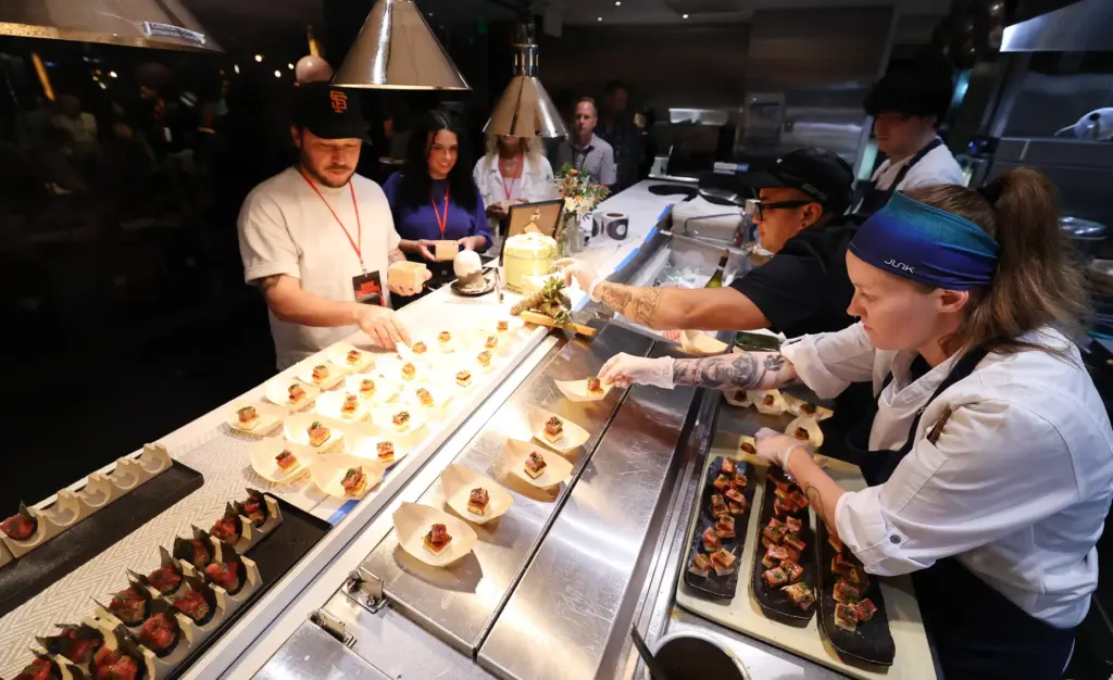 Guests interact with chefs including Chef Lex Bawgus, right, during...