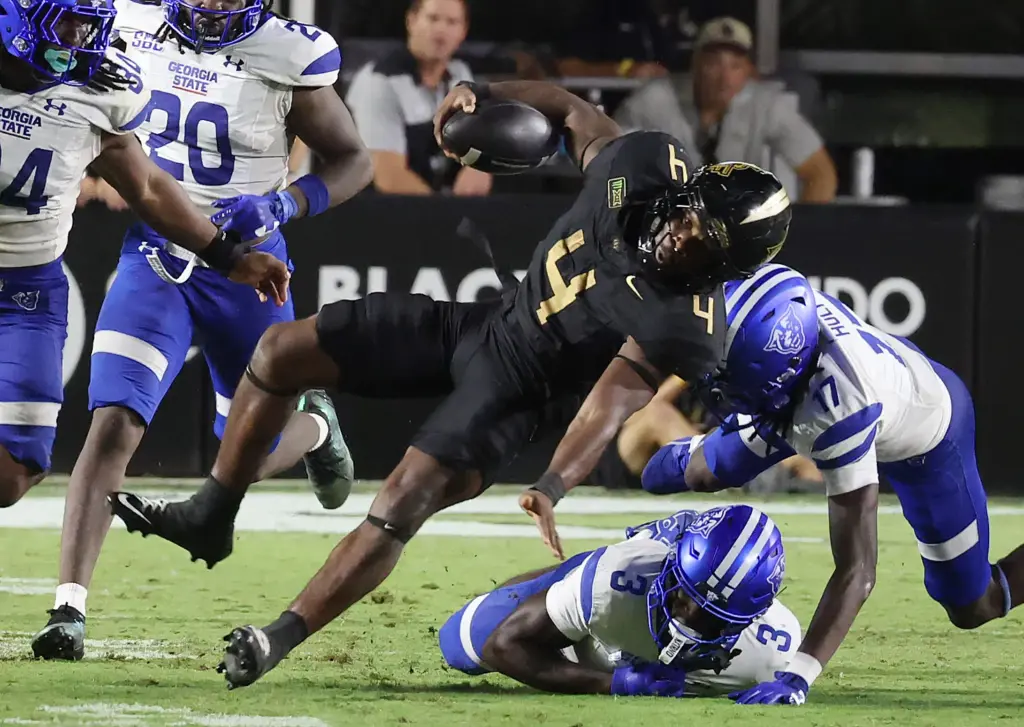 UCF running back Taevion Swint (4) runs through defenders during...