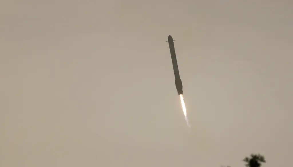 A SpaceX Falcon Heavy booster returns, after helping launch NASA's...