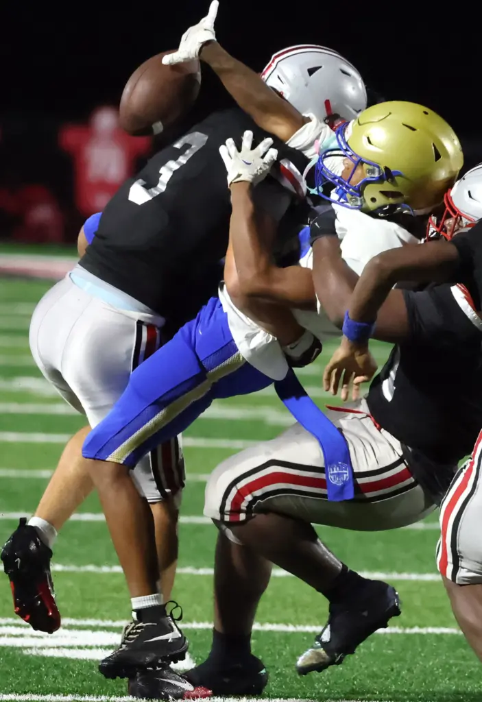 Lake Mary safety Sam Nelson (3) and others cause a...