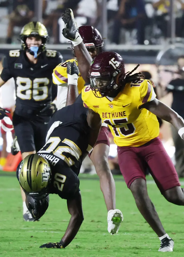 UCF running back Kaj Baker (20) is upended by BC...
