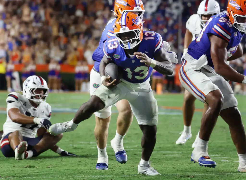 Florida running back Jadan Baugh (13) dances through the line...