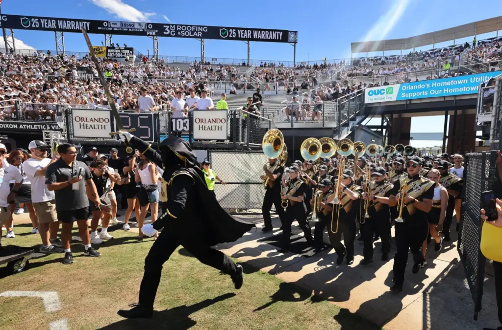 The UCF band runs onto the field for the TCU...