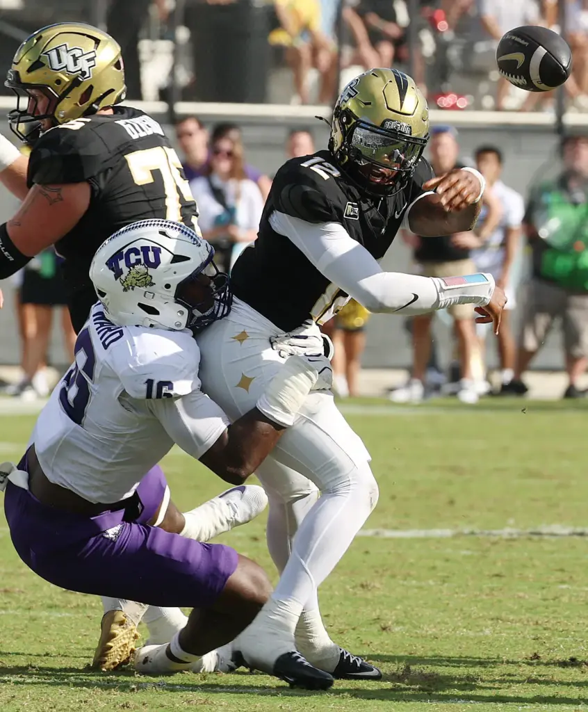 UCF quarterback Keyone Jenkins (12) throws in the grasp of...