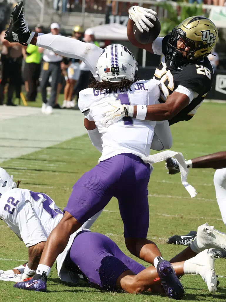 UCF running back Duke Watson (26) leaps into TCU cornerback...