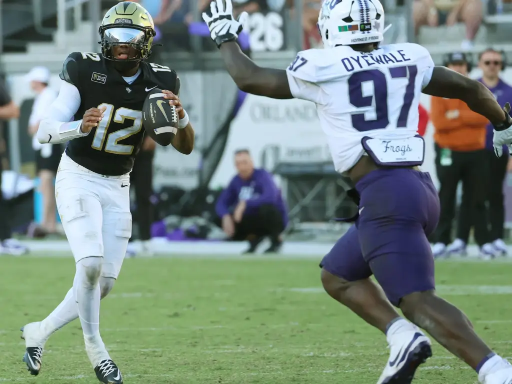 UCF quarterback Keyone Jenkins looks to pass while under pressure...