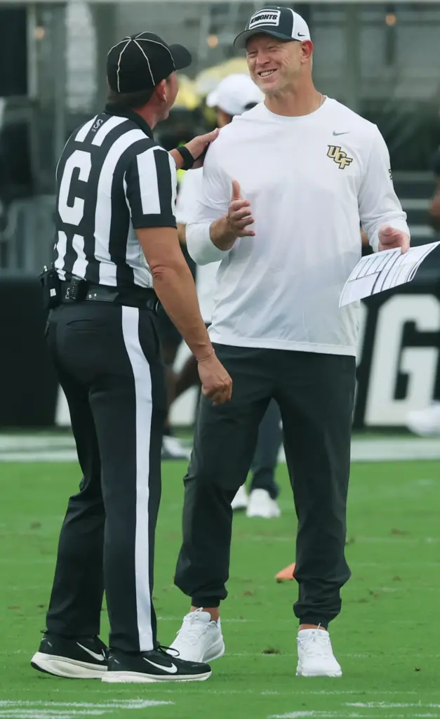 UCF head coach Scott Frost (right) smiles as he chats...
