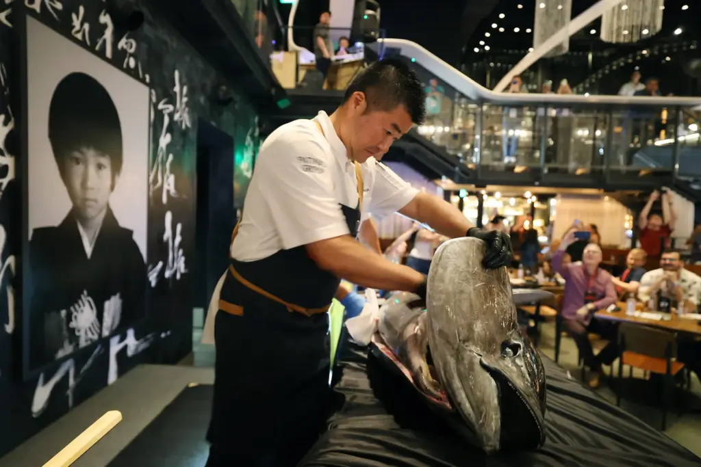 A huge tuna is carved during the Sushi Showdown at...
