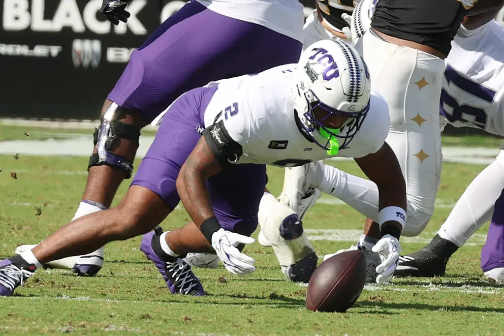 TCU running back Jon Denman falls on his own fumble...