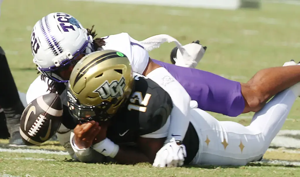 UCF quarterback Keyone Jenkins (12) fumbles as he is tackled...