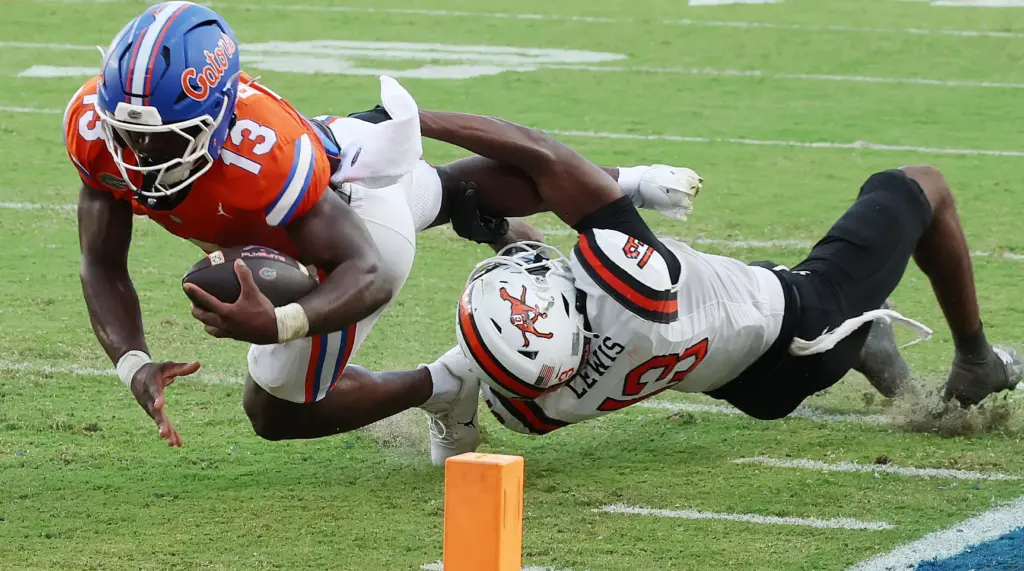 Florida running back Jadan Baugh (left) leaps for extra yardage...