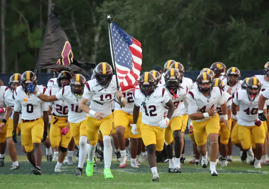 St. Cloud players run onto the field for the St....