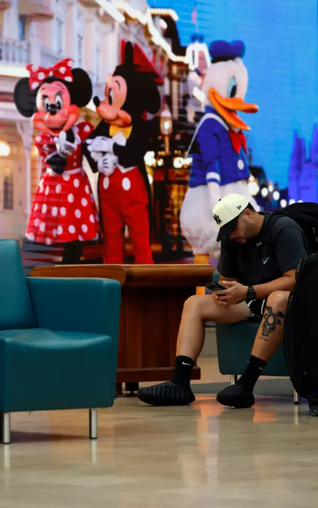 A traveler checks his phone at the Orlando International Airport,...