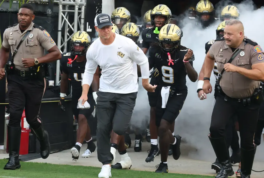 UCF head coach Scott Frost leads his players onto the...