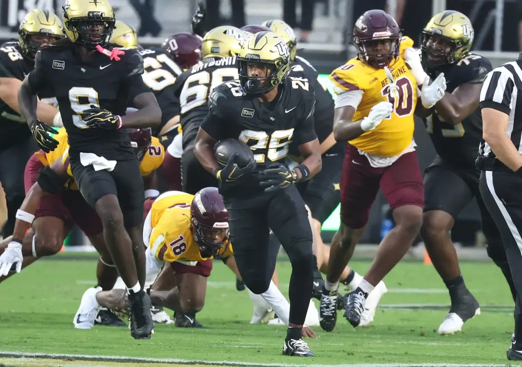 UCF running back Duke Watson breaks through the line to...