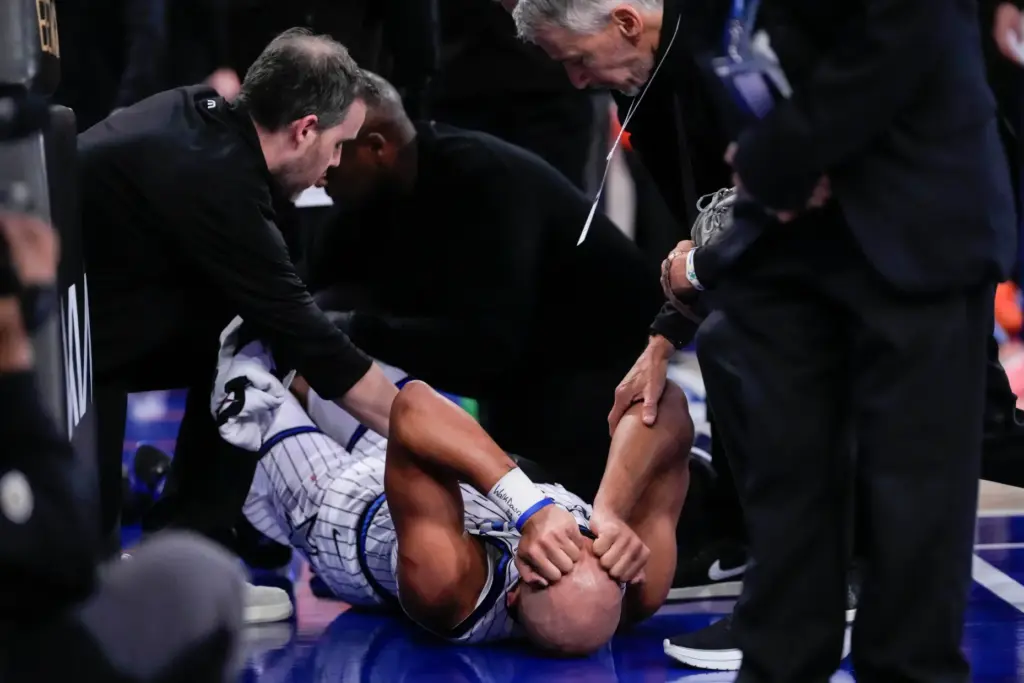 Orlando Magic guard Jalen Suggs, bottom, reacts after an injury...