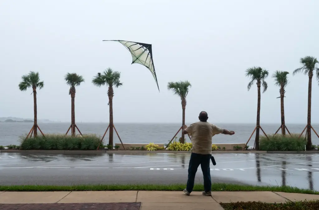Shawn Weaver flies a kite near the bridge connecting Gulf...