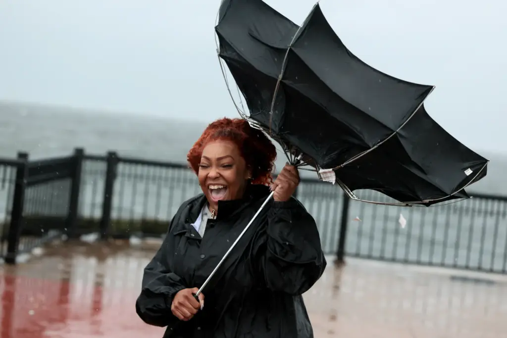 Qutanna Brooks reacts to the wind catching her umbrella as...
