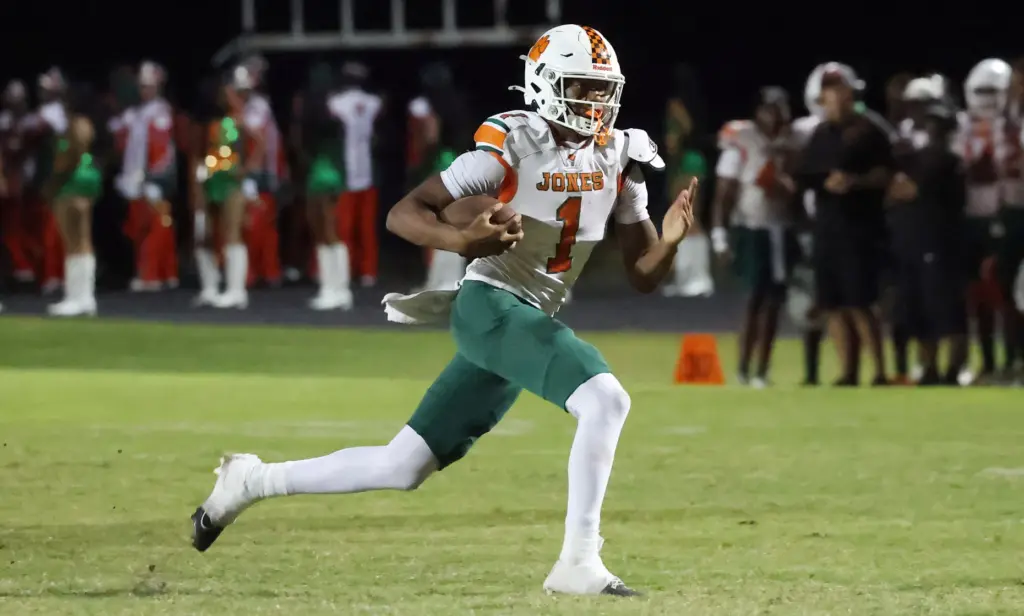 Jones High quarterback Peyton Carroll scrambles during the Jones High...
