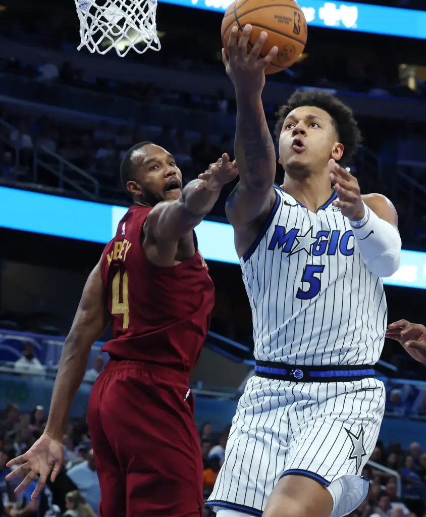 Orlando forward Paolo Banchero (5) shoots beside Cleveland center Evan...