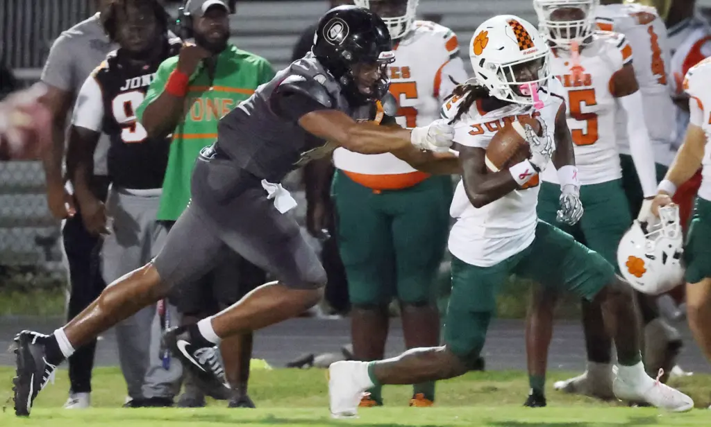 Ocoee High defensive end Cornelius Laney (left) grabs the jersey...