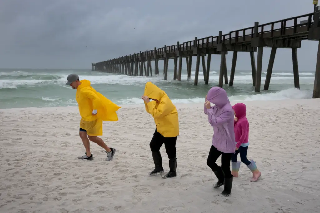 People visit the beach as waves churn in the ocean...