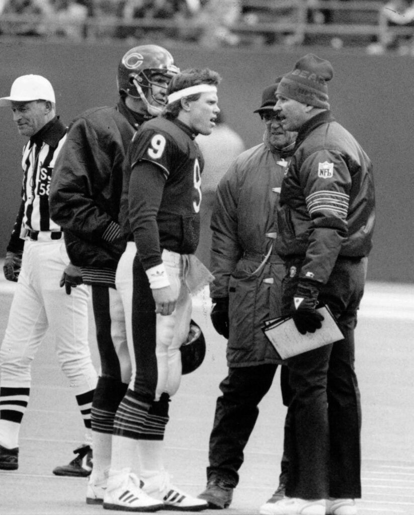 Coach Mike Ditka, center right, talks with quarterback Jim McMahon...