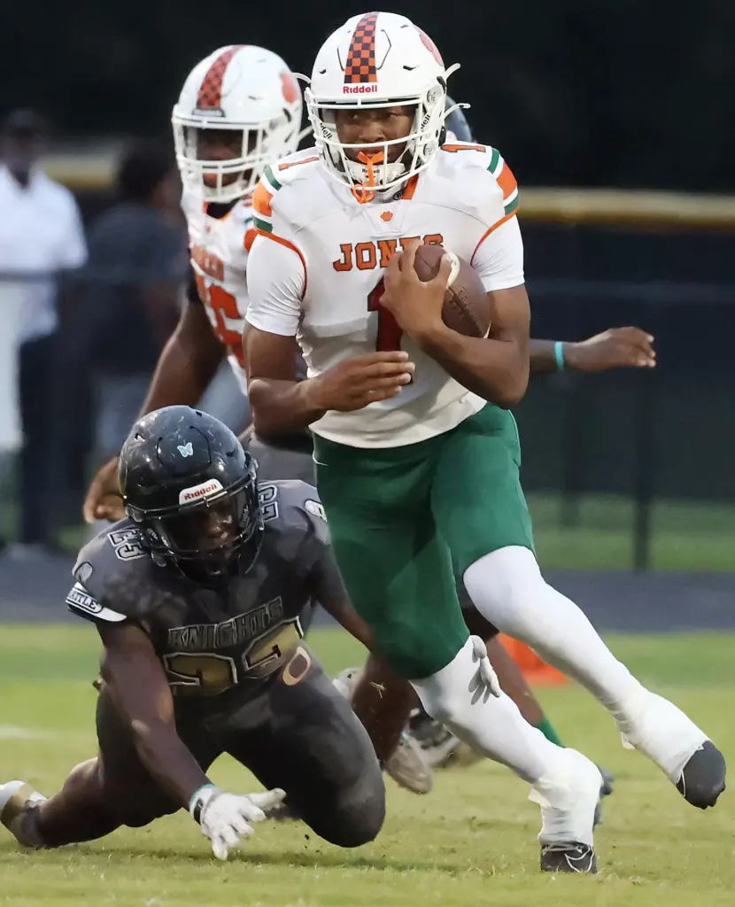 Jones High quarterback Peyton Carroll (1) scrambles during the Jones...